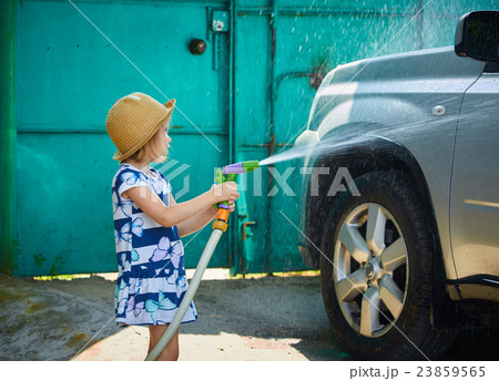 Little girl helps her parents to wash the car Little girl helps her parents to wash the car 23859565
