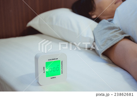 Young woman is sleeping with alarm clock Young woman is sleeping with alarm clock 23862681