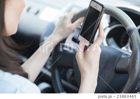 スマホを見ながら運転する女性 スマホを見ながら運転する女性 23863465