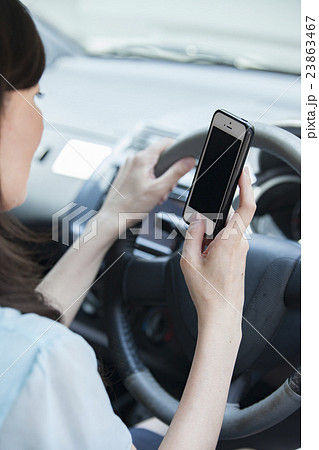 スマホを見ながら運転する女性 スマホを見ながら運転する女性 23863467
