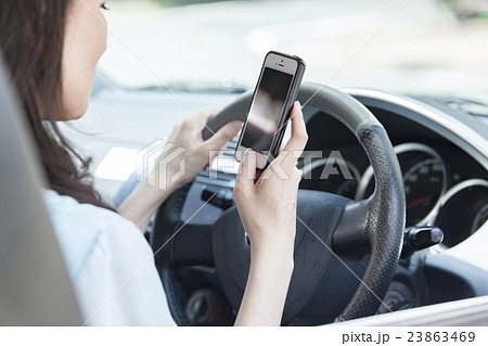 スマホを見ながら運転する女性 スマホを見ながら運転する女性 23863469
