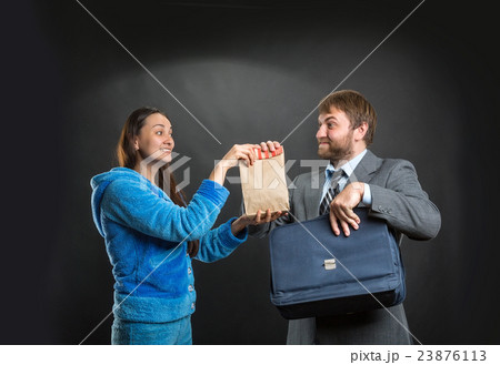 Wife giving pack with snack to her husband 23876113