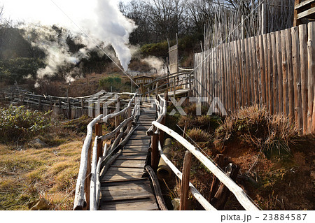 噴煙を上げる早朝の野天風呂通路 23884587