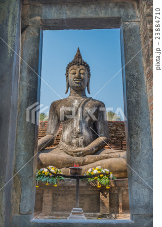 View of Sitting Buddha statue through stone door 23884710