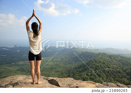 young woman practice yoga at mountain peak cliff 23890265