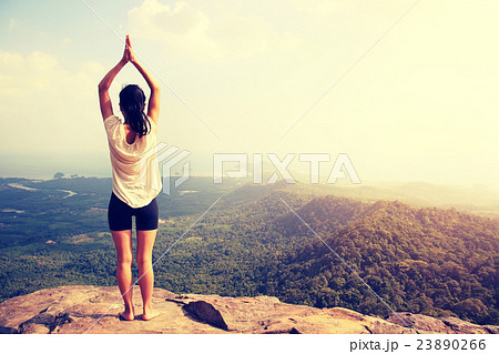 young woman practice yoga at mountain peak cliff 23890266