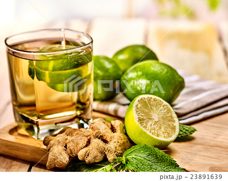 Glass with green transparent lime drink and ginger 23891639