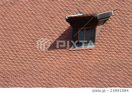 Mansard window in old tiled roof 23891984