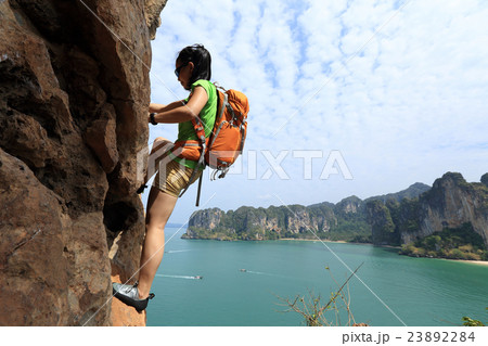 young woman rock climber climbing at seaside cliff young woman rock climber climbing at seaside cliff 23892284