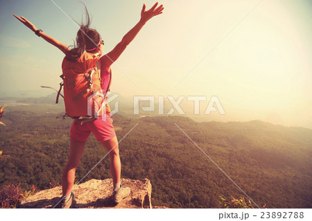 cheering young woman open arms on mountain peak cheering young woman open arms on mountain peak 23892788