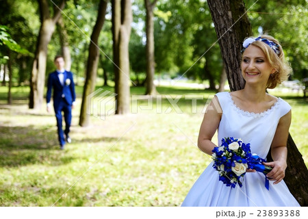 Groom approaches the bride in park 23893388