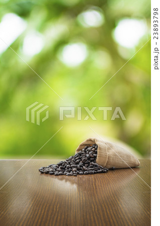 Coffee beans on wooden table in green background 23893798