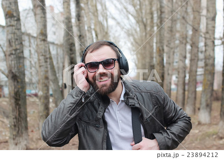 man with beard and headphones in the park man with beard and headphones in the park 23894212