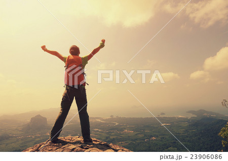 cheering woman hiker open arms at mountain peak 23906086