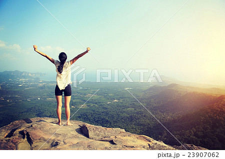 young freedom woman open arms on mountain peak.. 23907062