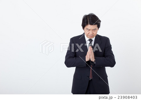 通夜でお悔みをするビジネスマン 23908403