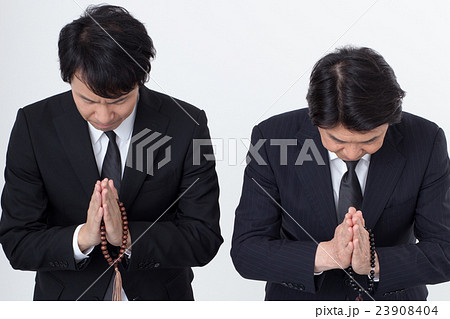 通夜でお悔みをするビジネスマン 23908404