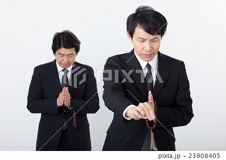 通夜でお悔みをするビジネスマン 23908405