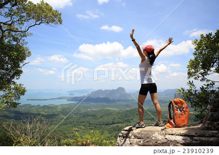 cheering woman hiker open arms on mountain peak cheering woman hiker open arms on mountain peak 23910239
