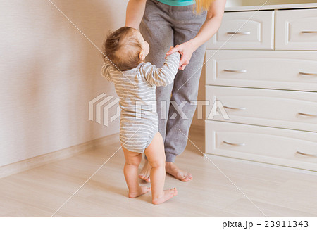 Cute smiling baby boy learning to walk Cute smiling baby boy learning to walk 23911343