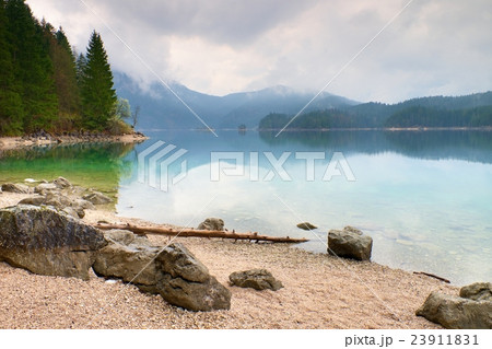 Mountain lake before sunset.Tree fallen into water Mountain lake before sunset.Tree fallen into water 23911831