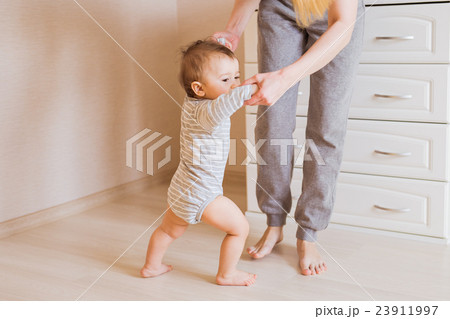 baby taking first steps with mother help baby taking first steps with mother help 23911997