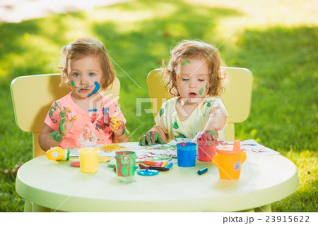Two-year old girls painting with poster paintings Two-year old girls painting with poster paintings 23915622