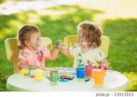 Two-year old girls painting with poster paintings 23915623