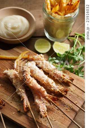 crumbed prawn skewers with potato fries 23916032