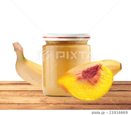 Jar of baby puree, peach and banana on wood table 23916669