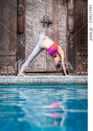 Asia woman doing yoga beside swimming pool Asia woman doing yoga beside swimming pool 23917481