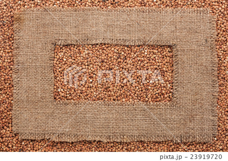 Frame made of rough burlap lies on buckwheat grain 23919720