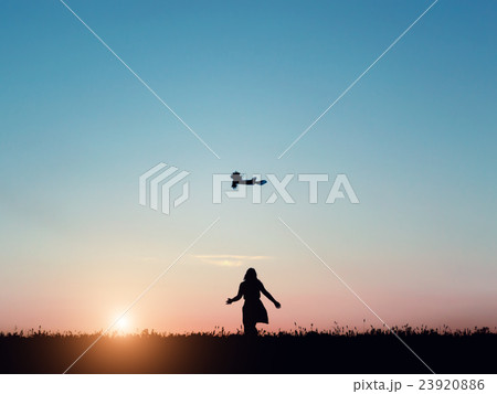 Silhouette of a beautiful girl jumping over sunset 23920886