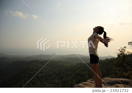 fitness woman open arms at mountain peak cliff fitness woman open arms at mountain peak cliff 23921732