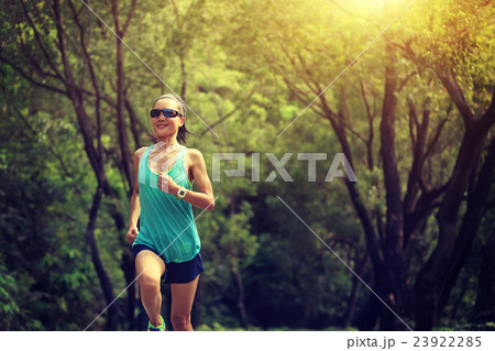 young fitness woman trail runner running in forest 23922285