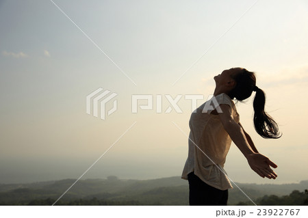 young freedom woman open arms on mountain peak 23922767