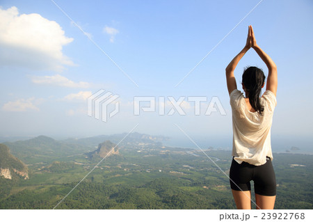 fitness woman practice yoga at mountain peak cliff 23922768