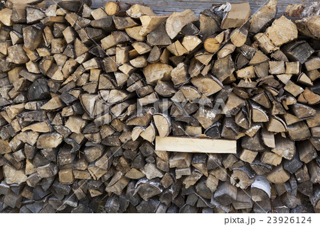 A pile of firewood at the wall of the wooden house A pile of firewood at the wall of the wooden house 23926124