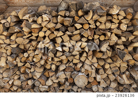 A pile of firewood at the wall of the wooden house 23926136