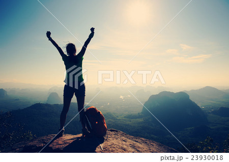 cheering woman hiker on sunrise mountain peak cheering woman hiker on sunrise mountain peak 23930018