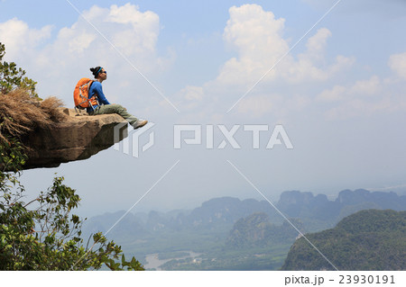 young woman hiker at mountain peak cliff.. 23930191