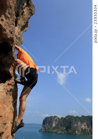 young woman rock climber climbing at seaside rock young woman rock climber climbing at seaside rock 23930304