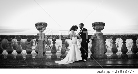 Groom looks at a stylish bride while posing Groom looks at a stylish bride while posing 23933777