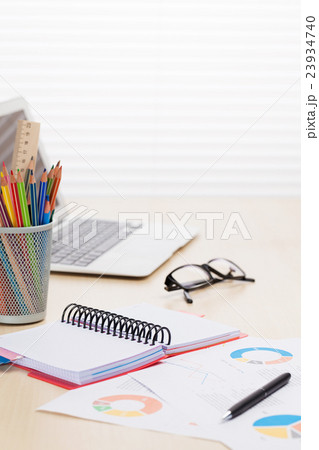 Office workplace with laptop, reports and pencils 23934740