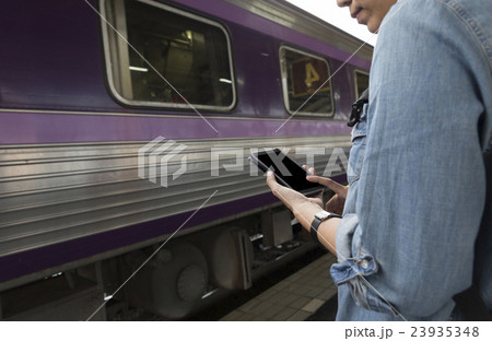 woman holding smartphone backpack at train station woman holding smartphone backpack at train station 23935348