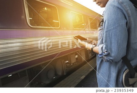 woman holding smartphone backpack at train station woman holding smartphone backpack at train station 23935349
