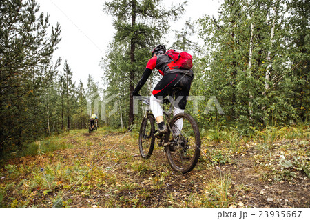 male athlete riding through in forest 23935667