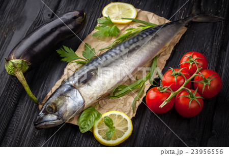 Mackerels served on parchment with lemon, tomatoes 23956556