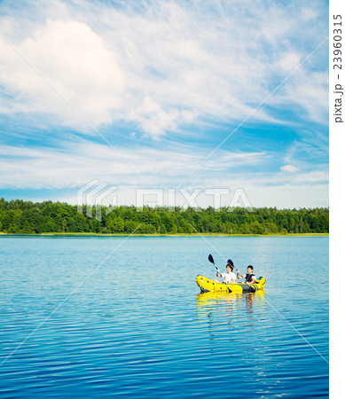 Two Men Paddle a Kayak on Lake. Lifestyle Concept. 23960315