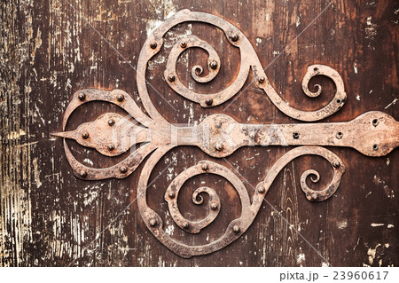 Old rusted forged decorative door hinge Old rusted forged decorative door hinge 23960617